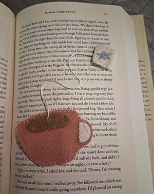 a felt bookmark in the shape of a teacup with a teabag coming from its top