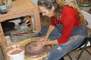 a photo of Ann Buchau at the pottery wheel