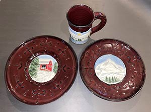 a photo of a mug and two plates, objects made by the teacher