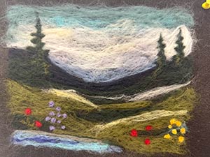 a landscape of trees, meadow and brook made with needle felting