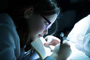 a photo of a closeup of a girl writing in a diary