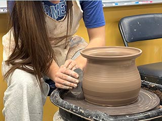 several pieces of pottery in a red, white, green and strawbery motif, examples for the imtermediate pottery class